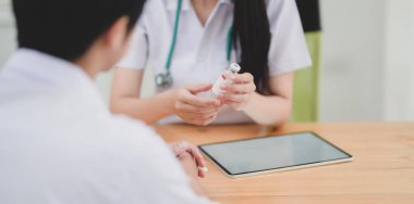 Genç bayan doktor, hastasına tıbbi eşkalini açıklıyor. 