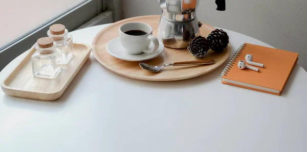 Xícara de café e pote Moka em bandeja de madeira em mesa de madeira branca com material de escritório — Fotografia de Stock