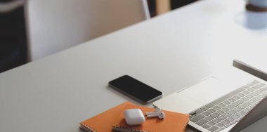 Akıllı telefon ve ofis malzemeleri beyaz ahşap masa üzerinde modern iş yerinin yakın görüntüsü 