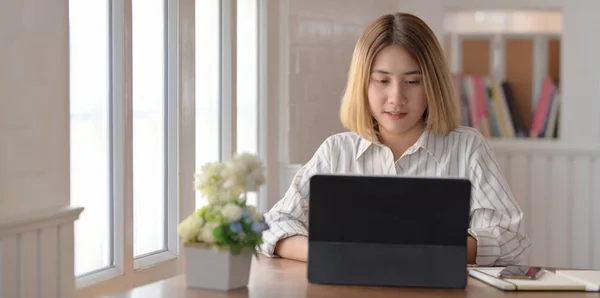 Giovane bella donna d'affari che lavora al suo progetto mentre digita sul tablet in un posto di lavoro confortevole — Foto Stock