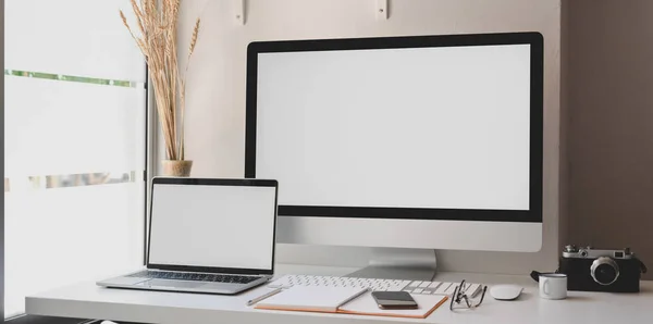 Pusty ekran komputera stacjonarnego i laptopa w nowoczesnym obszarze roboczym z materiałami biurowymi — Zdjęcie stockowe