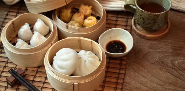 Overhead shot of Chinese steamed dumpling and steamed pork bun in a bamboo steamer — Stok Foto