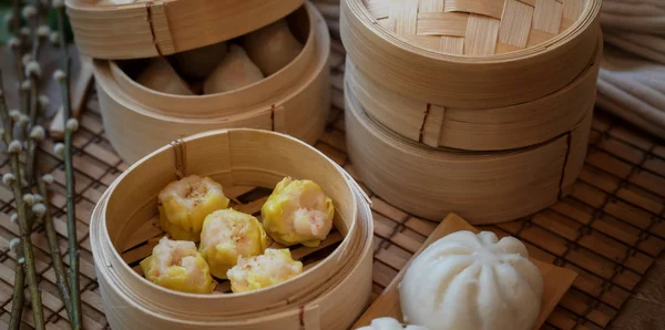 Обрезанный кадр китайской клёцки и свиная булочка на бамбуковом пароходе — стоковое фото