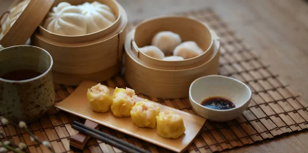 Chinese steamed dumpling and steamed pork bun in a bamboo steamer