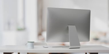 Beyaz masadaki masaüstü bilgisayarı ve modern ofis odasındaki bulanık arka planı olan kahve fincanı. 