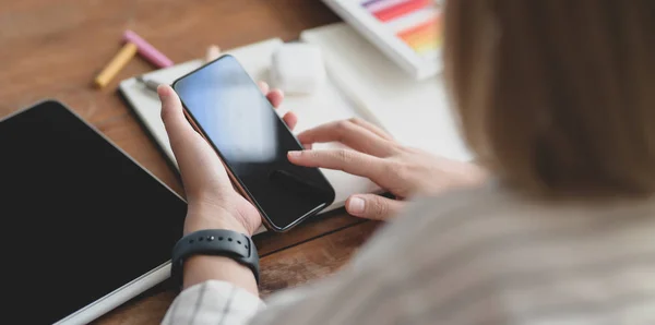 Cropped shot of young female designer touching smartphone — ストック写真