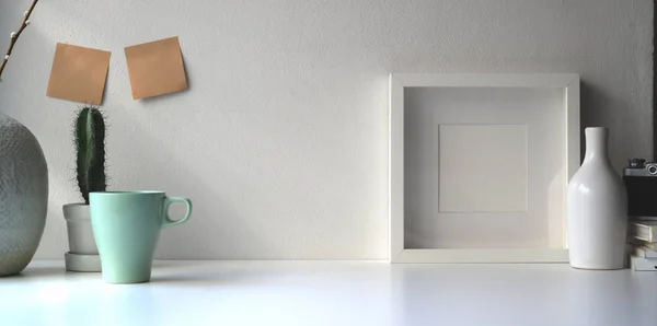 복사 공간 이 있는 흰 벽에 흰 탁자 위에 흰색 틀 과 도자기 단지를 놓는다 — 스톡 사진