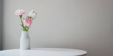 Beyaz masa üzerindeki vazo süslemeleri. Fotokopi alanı ve beyaz duvar arkaplanı. 