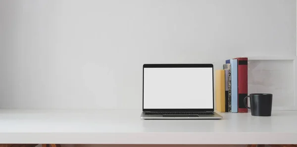带有书的开放式空白屏幕笔记本电脑和白色桌子上的复制空间的最小工作空间 — 图库照片