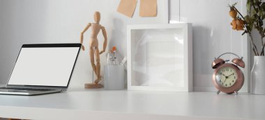 Boş dizüstü bilgisayarı olan çağdaş iş yeri ve ofis malzemeleriyle çerçeve oluşturma