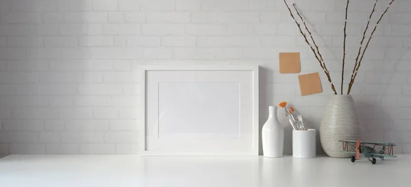 Minimale werkruimte met kopieerruimte en mock up frame met boeken op witte tafel en witte wand achtergrond — Stockfoto