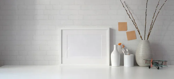 Espace de travail minimal avec espace de copie et cadre maquette avec livres sur table blanche et fond mural blanc — Photo