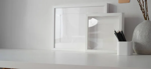 Espacio de trabajo mínimo con marco simulado y espacio de copia, escritorio blanco y fondo de pared blanco —  Fotos de Stock