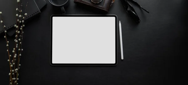 Bovenaanzicht van blanco scherm digitale tablet op blanco bureau in donkere luxe werkruimte met kantoorbenodigdheden — Stockfoto