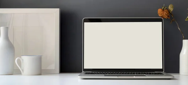 Minimales Bürozimmer mit offenem leeren Bildschirm Laptop-Computer mit Attrappe Rahmen Dekorationen — Stockfoto