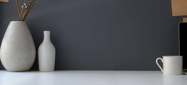 Espace de travail moderne avec espace de copie et vase en céramique sur table blanche et fond mural gris — Photo