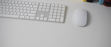 Bilgisayarlı, kitaplı ve beyaz masadaki basit ofis masasının kırpılmış görüntüsü 