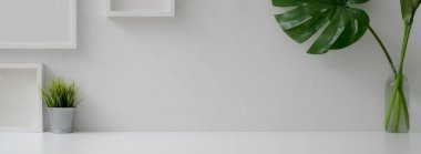 Fotokopi alanı, maket çerçeveleri ve beyaz duvarlı bitki vazoları ile minimal ev iç tasarımı görünümünü kapat 