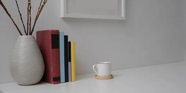 Cropped shot of modern home interior design with books, ceramic vase, mock-up frame and copy space