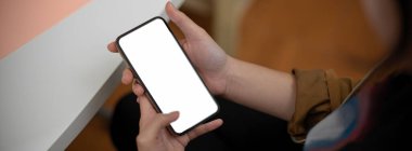 Çalışırken boş ekran akıllı telefonu kullanan serbest çalışan kadın görüntüsü.