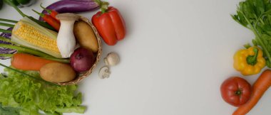 Çeşit çeşit taze çiftlik sebzelerinin ve beyaz mutfak masasının üstündeki kopyalama alanının en üst görüntüsü