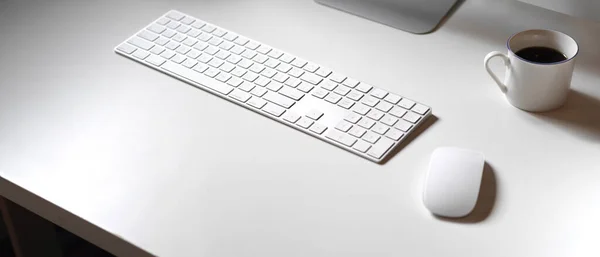 Cropped shot of minimal office desk with computer devices, coffee cup and copy space