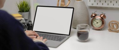 Model dizüstü bilgisayar, kahve fincanı, kamera ve modern ofis dekorasyonlarıyla çalışan serbest çalışan bir kadın.