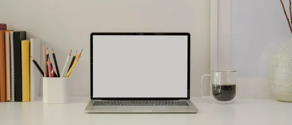 モックアップノートパソコン 文房具 コーヒーカップ 白い机の上の装飾が施されたシンプルな家庭用オフィスのビューを閉じます — ストック写真