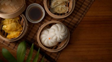 Bambu terzide servis edilen buharda pişirilmiş mantı ve ahşap masada fotokopi alanı ile sıcak çay. 