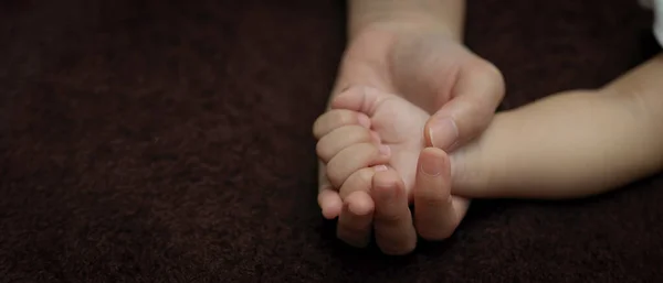 妈妈的手抱着小宝宝躺在床上的近景 — 图库照片