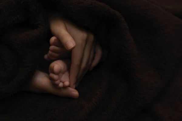 Mãe Mãos Segurando Recém Nascido Bebê Pés Fundo Escuro — Fotografia de Stock