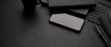 Akıllı telefon, kupa, ofis gereçleri ve fotokopi alanı ile lüks çalışma alanının eksiltilmiş görüntüsü.