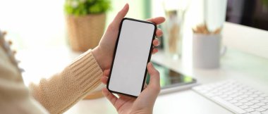 Çalışabilir durumdayken bilgi göstermek için kadın ellerinin maket akıllı telefonu tutuş görüntüsünü kapat
