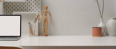 Modern çalışma tablosunu, dizüstü bilgisayar, fırça, kupa, süsleme ve beyaz masadaki kopyalama alanı ile kapat