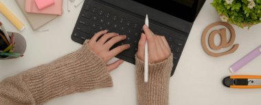 Klavyeli dijital tablet ve kırtasiyeli beyaz kalemli kadın öğrencilerin el resimleri.