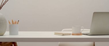 Bilgisayarla, malzemelerle, dekorasyonla ve ofisteki basit çalışma alanının görüntüsünü kapat