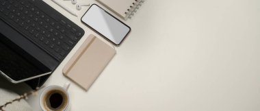 Fotokopi alanı, dijital cihazları, kırtasiyesi ve kahve fincanı olan modern ofis masasının üst görünümü 