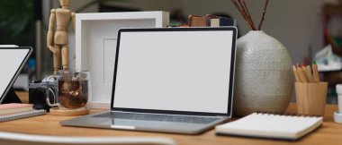 Laptop, kırtasiye malzemesi, kahve fincanı, malzeme ve dekorasyon ile ofis masasının kırpılmış görüntüsü.. 