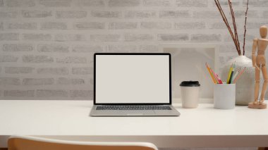 Modern çalışma alanının görünümünü laptopla, kırtasiyeyle, dekorasyonla ve beyaz masadaki sandalyeli kopyalama alanıyla kapat  