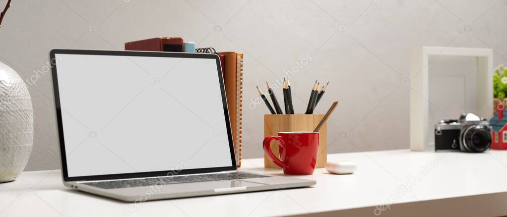 Cropped shot of computer laptop with clipping path on white table with stationery and decorations in home office