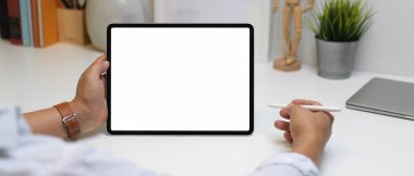 Çalışma odasındaki çalışma alanında kırpma yolu olan tablet kullanan erkek girişimcinin görüntüsünü kapat