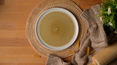 Ahşap mutfak masasının üst manzarası. Plasemat, mutfak aletleri, masa örtüsü ve dekorasyonla birlikte. 