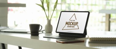 Tablet, akıllı telefon, defterler, malzemeler ve cam duvar ofis dekorasyonu ile çalışabilir görüntüler.