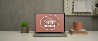 Çalışma masası görünümünü çatı katında dizüstü bilgisayar, not defteri, kupa ve dekorasyonla kapat 