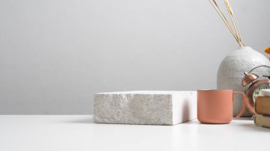 Beyaz masayı taş, kupa, malzeme, vazo ve fotokopi odasıyla kapatın. 