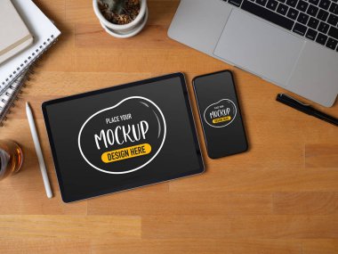 Çalışma alanının en üst görünümü tablet, akıllı telefon, dizüstü bilgisayar, kırtasiye ve ahşap masa dekorasyonu ile 