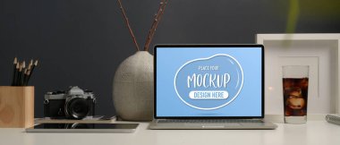 Ofis masasının görüntüsünü kapatıyoruz. Tablet, tasarımcı malzemeleri, vazo ve kahve fincanı ofis odasında.