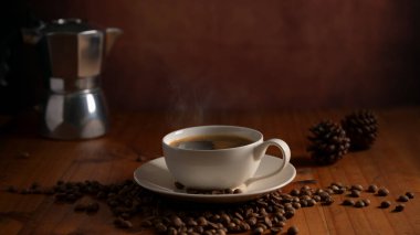 Kahve çekirdekleri ile süslenmiş ahşap masanın üzerindeki kahve fincanını kapat. 