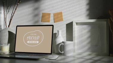 Dizüstü bilgisayar, ofis malzemeleri ve dekorasyonlarla dolu rahat bir çalışma alanı. 