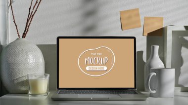 Beyaz ofis aksesuarlarıyla beyaz ofis aksesuarlarının oluşturduğu dizüstü bilgisayarla beyaz minimal çalışma alanının yakın görüntüsü